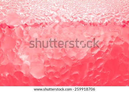 Red juice frozen water drops on glass