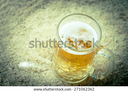 vintage retro style and soft focus,Glass of beer on the beach
