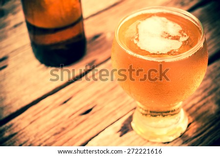 vintage retro style and soft focus,Glass of beer on wood table