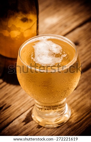 vintage retro style and soft focus,Glass of beer on wood table