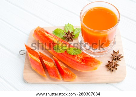 Papaya juice with papaya fruit on wood
