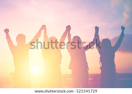 Silhouette of happy business team making high hands in city background for business teamwork concept