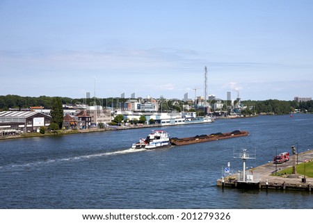 Amsterdam, Netherlands - August 10, 2012 : Coal barge traveling the shipping channel near the Port of Amsterdam