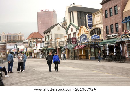 Atlantic City, NJ, USA - May 18, 2011 : Tourists on Boardwalk in Atlantic City, New Jersey with shops and casinos in background.
