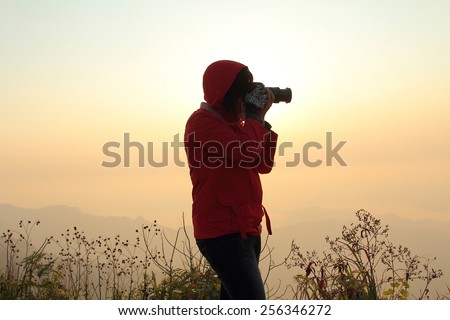 Photography of female photographer during the sunset at PHU CHEEFA PARK , Chiangrai in Thailand