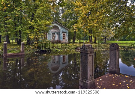 Classical pavilion next to water in the autumn park