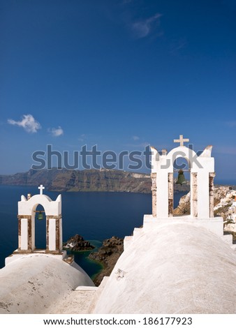 Santorini view with bell-towers of white churches and coastline