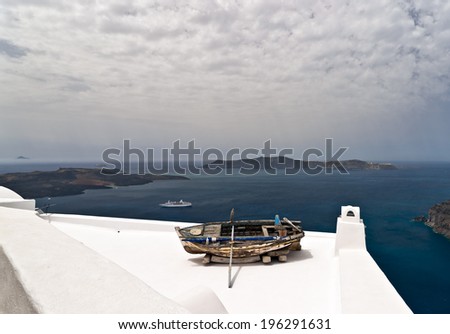 Santorini island with the boat as a decoration of the house roof