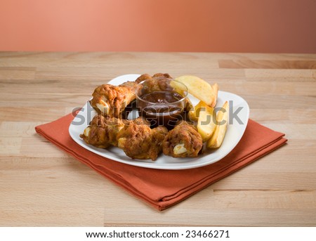 Fried chicken drumstick with potato and hot sauce