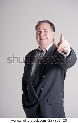 Business man in suit laughing and pointing as if with an idea