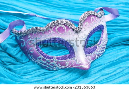 The purple silver mask on turquoise fabric