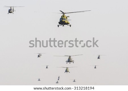 A group of military helicopters flying on the background of blue sky