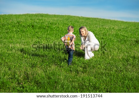 Beautiful boy and mom in spring park with present. Mothers day or birthday celebration concept