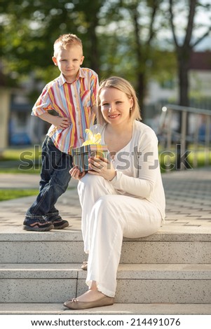 Cheerful young boy with a gift for Mom on Mother\'s Day