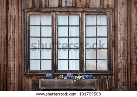 Three rustic windows with a window flower box