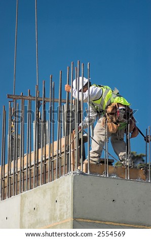 A construction worker releasing a concrete form from a wall.