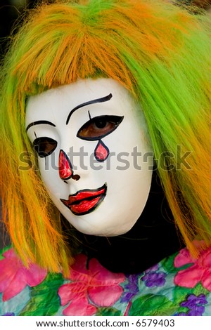 A woman wearing a colorful sad clown halloween costume.