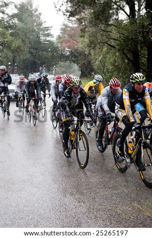 SANTA CRUZ, CA - February 16, 2009: Bicyclers in the Amgen Tour of California 2009 race riding through a rainstorm in the Santa Cruz Mountains on February 16, 2009.