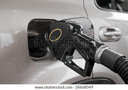 A gasoline pump nozzle in the tank of an automobile.