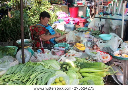 Bangkok, Thailand- June 11, 2015:  Fresh fruit and vegetable stall in Bangkok. The women sorting the chillies while waiting for customers.
