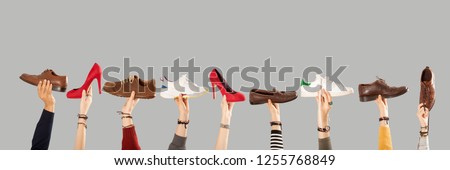 many shoes on arm raised hands