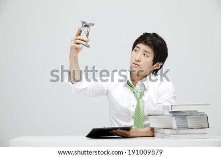 Asian businessman at desk looking at time
