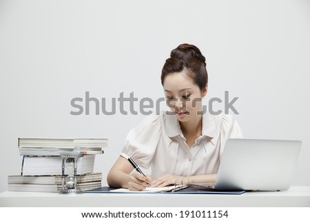 Asian business woman sitting at desk doing work