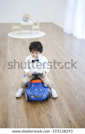 the image of cute Korean boy on toy car