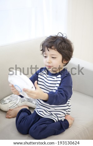 the image of cute Asian kid with gaming console