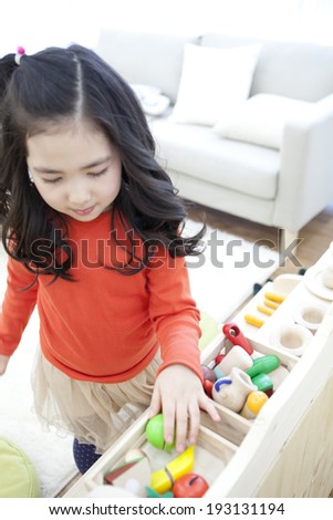 Cute Korean kids playing with wooden tea set