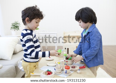 Cute Korean kids playing with tea set