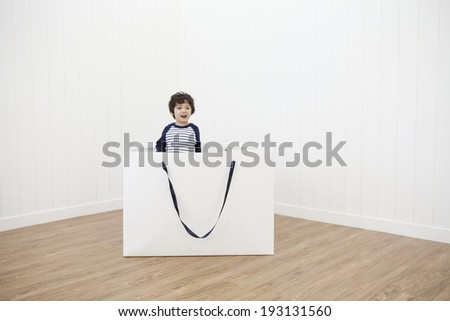 the image of cute Asian kid inside paper bag