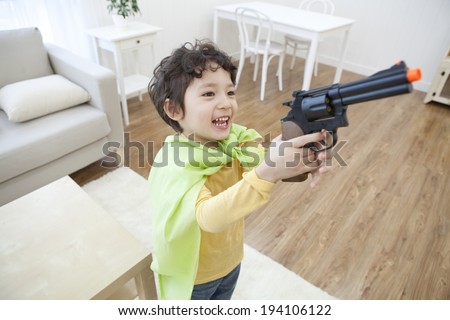 the image of cute Asian kid with toy gun