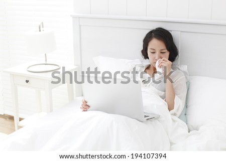 the image of Korean businesswoman and working at home in bed