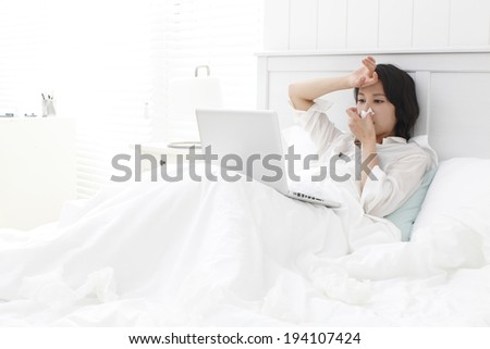 the image of Asian businesswoman and working at home in bed