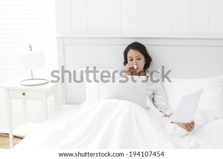 the image of Asian businesswoman and working at home from bed