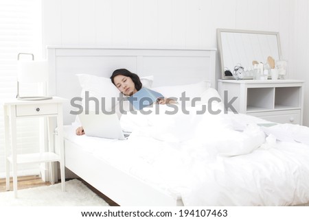 the image of Korean businesswoman and working at home in bed