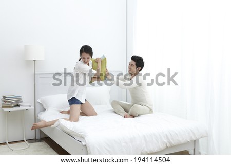 Asian woman having pillow fight