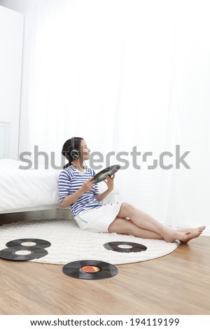 the image of Asian woman listening to vinyls
