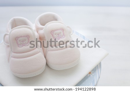 the image of giving birth and pink baby shoes