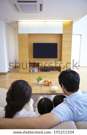 the image of a happy Asian family watching TV