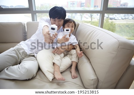 the image of a happy Asian father and son with toy guns