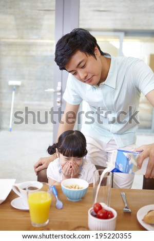 the image of a happy Asian family preparing breakfast
