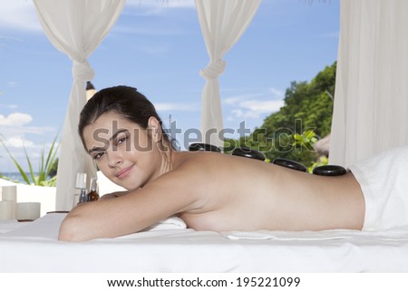 Asian woman having a hot stone back treatment