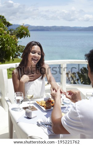Marriage proposal at restaurant by the sea