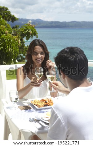 Asian couple drinking by the sea
