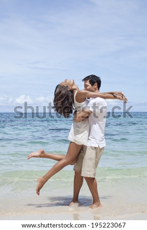 Asian couple hugging by the sea in Boracay in Philippines