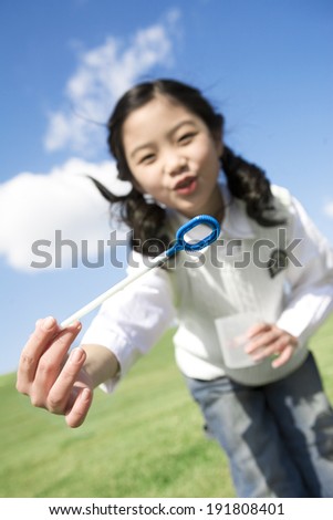 The image of Korean smiling girl blowing bubbles