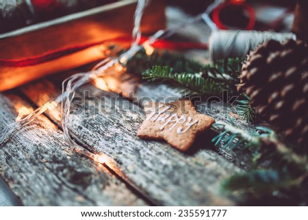 Christmas mood still life on a rustic background with pine cone, Happy holidays gingerbread cookie and lights