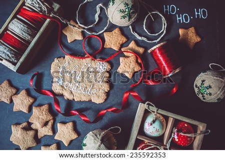 Baby it's cold outside gingerbread cookies with ribbons and vintage ornaments on a black background